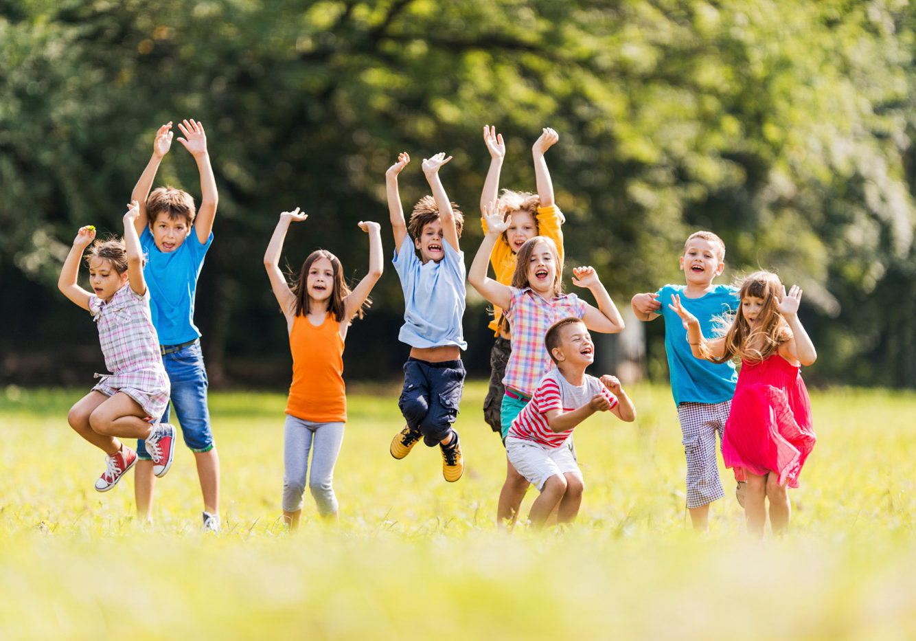Playful Children In The Park. Large group of children jumping in the park and having fun.